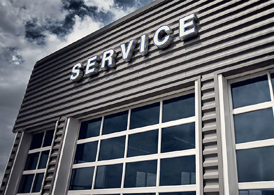 A service sign with white lettering on a gray garage