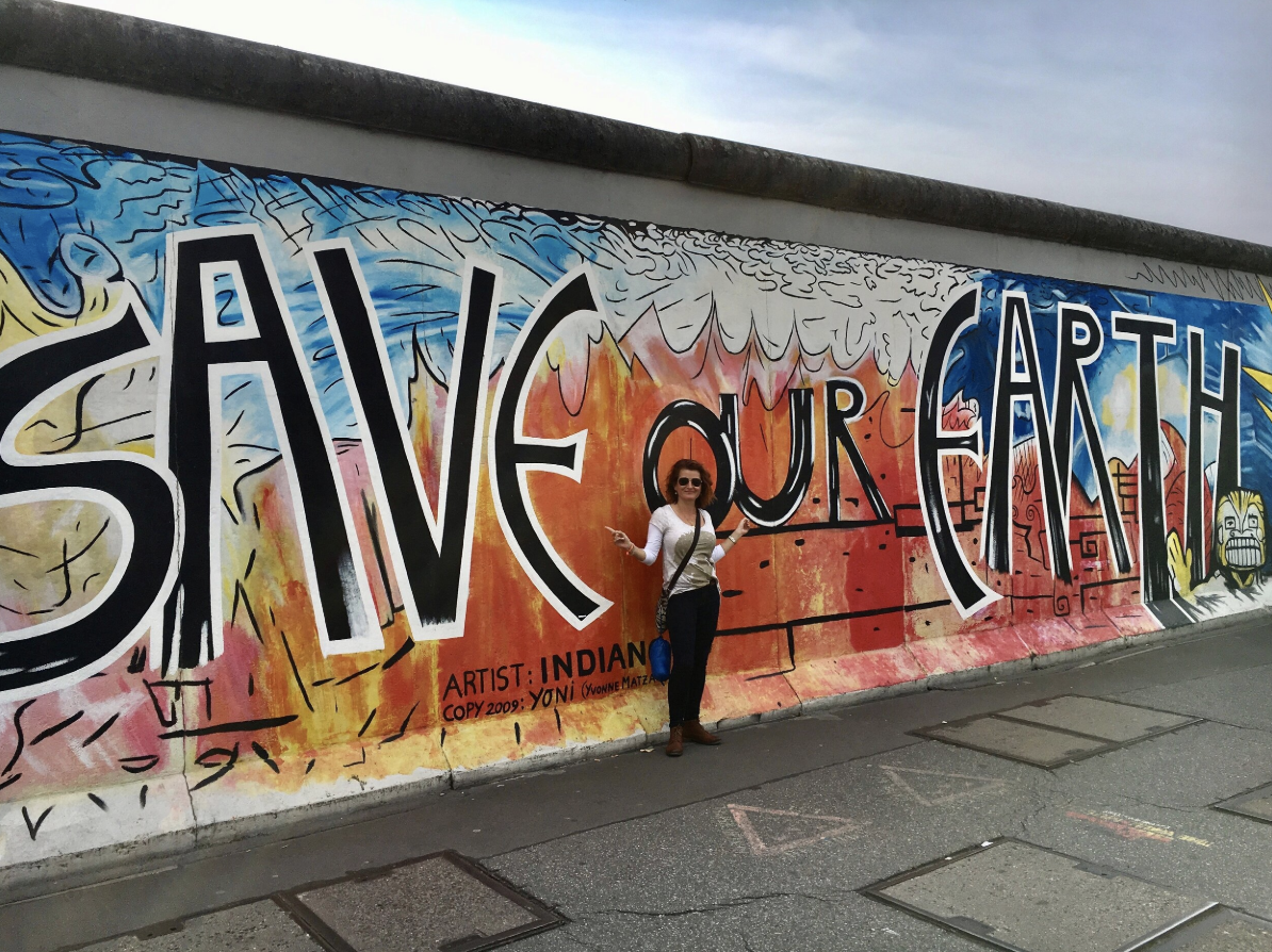 the-green-maya-project-founder-sara-renshaw-in-front-save-our-earth-sign