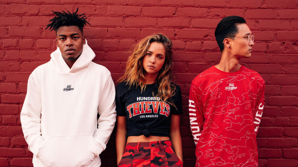 3 models in streetwear pose over brick wall