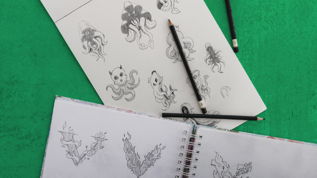sketchbooks and pencils over green background