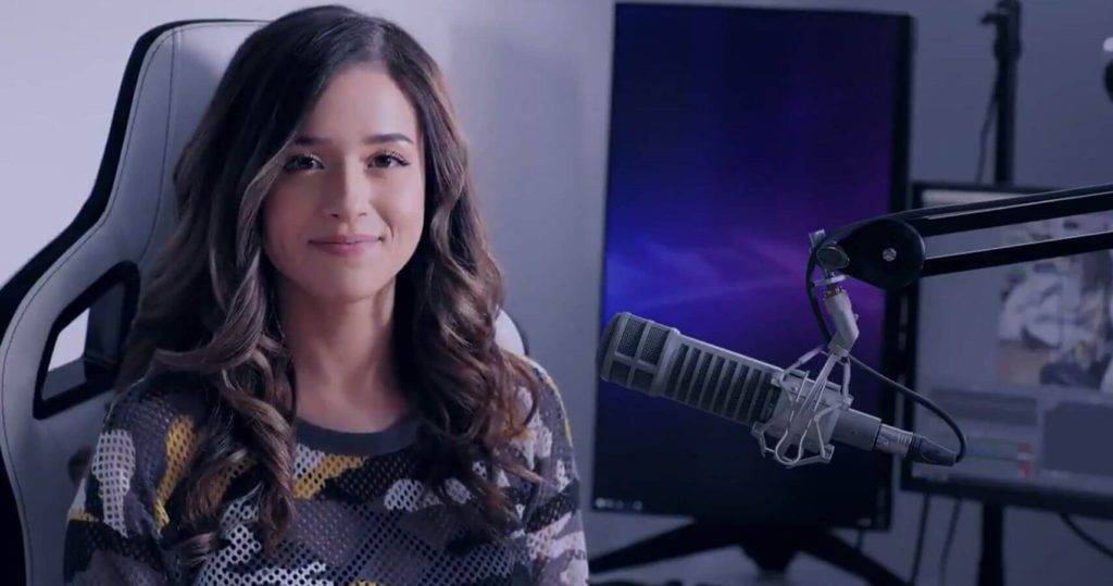 Pokimane Streamer Smiles in Gaming Chair before monitor and microphone