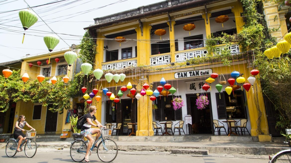 Hoi an Old town street with tourists on bicyles, included in tours offered by Asia Vacation Group