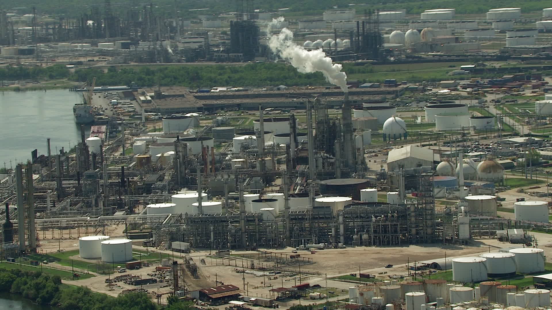HD stock footage aerial video approach an oil refinery by the river in