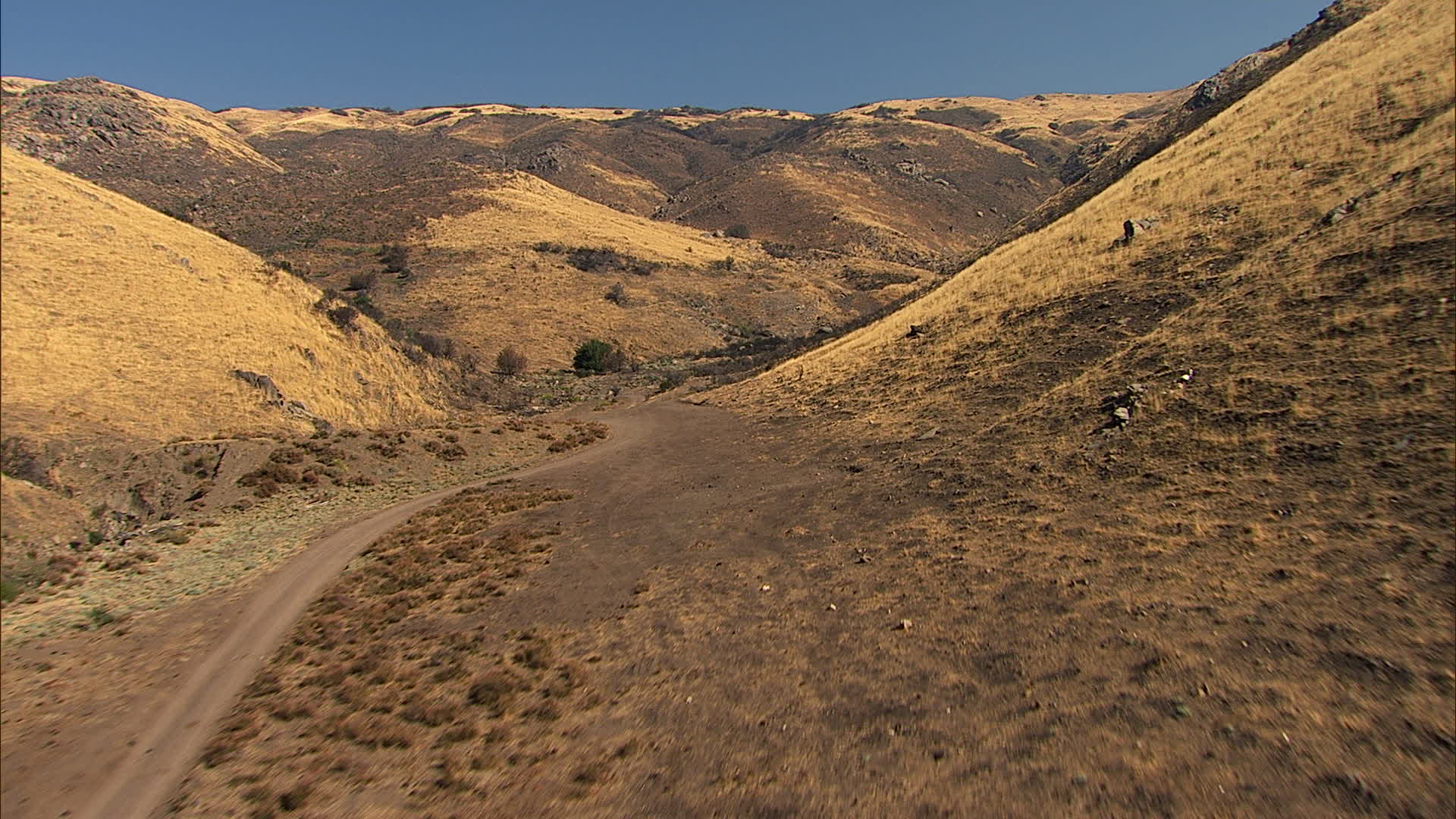 HD stock footage aerial video of following a dirt road into the hills