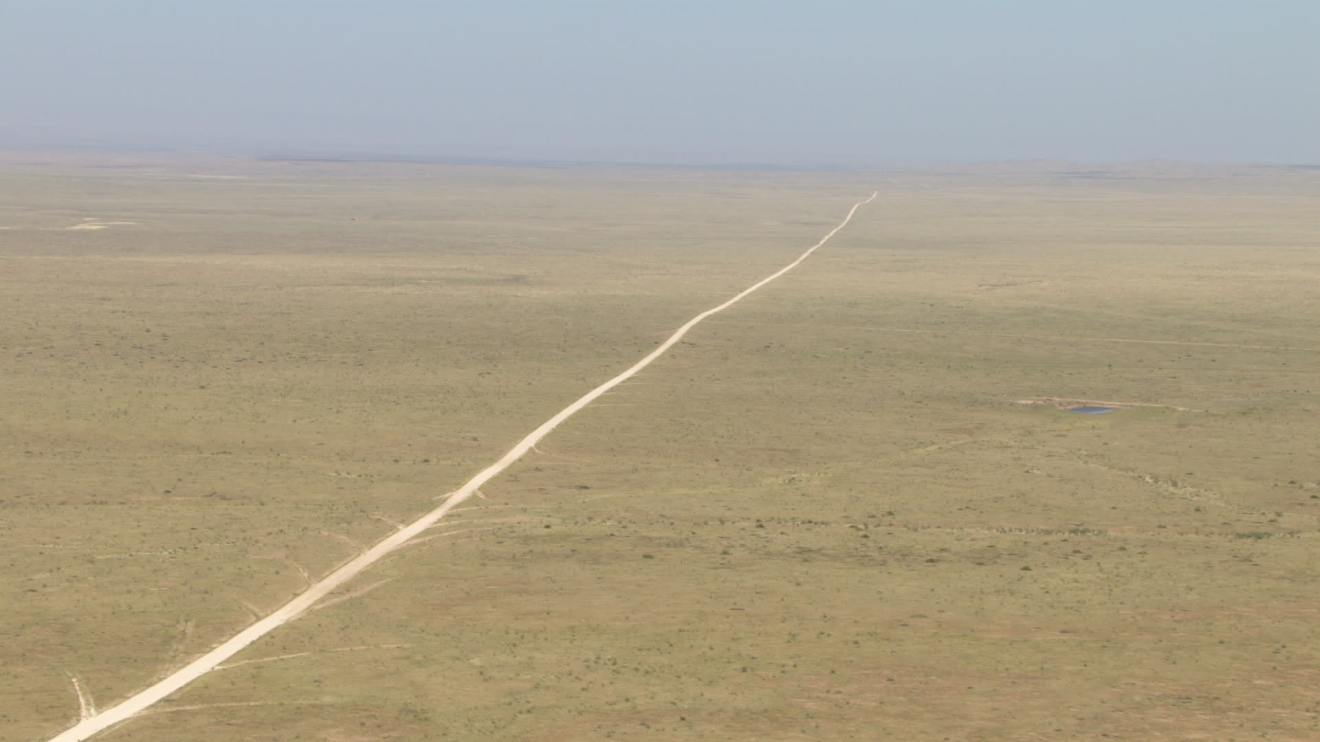 HD stock footage aerial video of a dirt road through a wide desert
