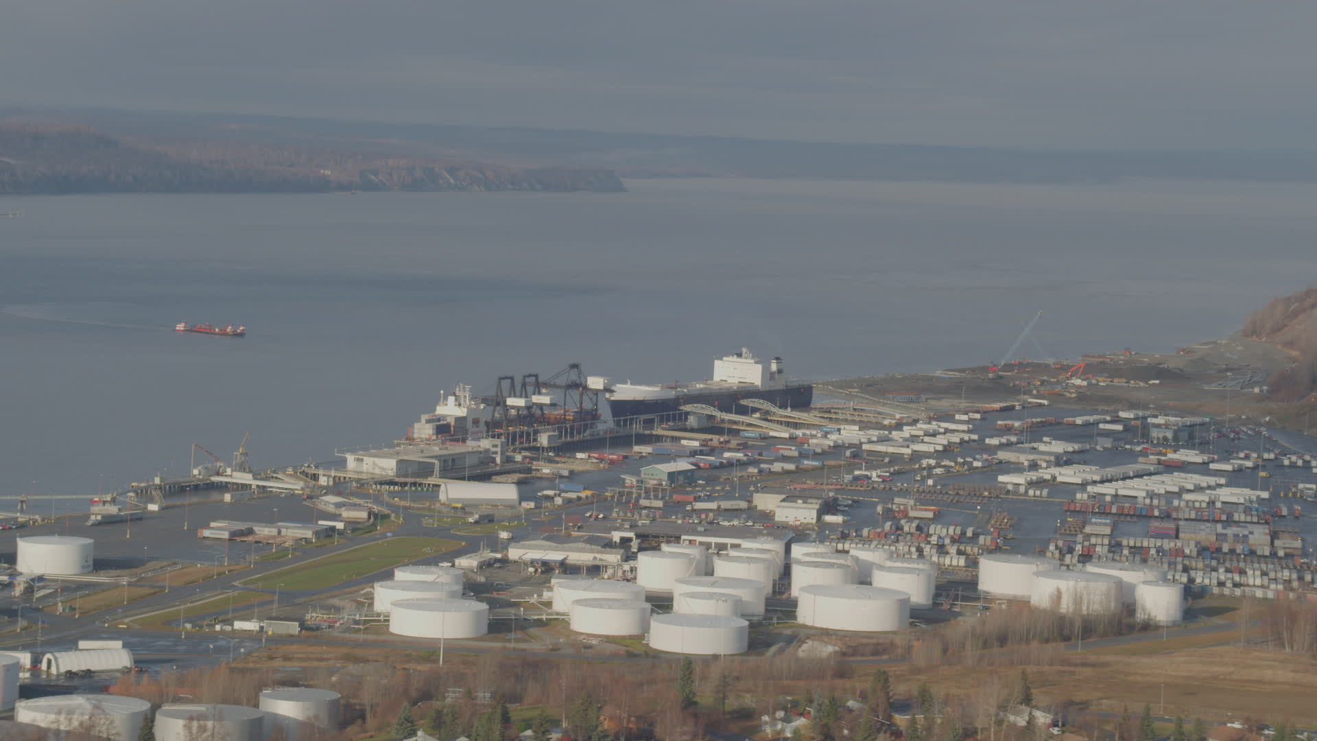 4K stock footage aerial video large tanks and a cargo ship at the port
