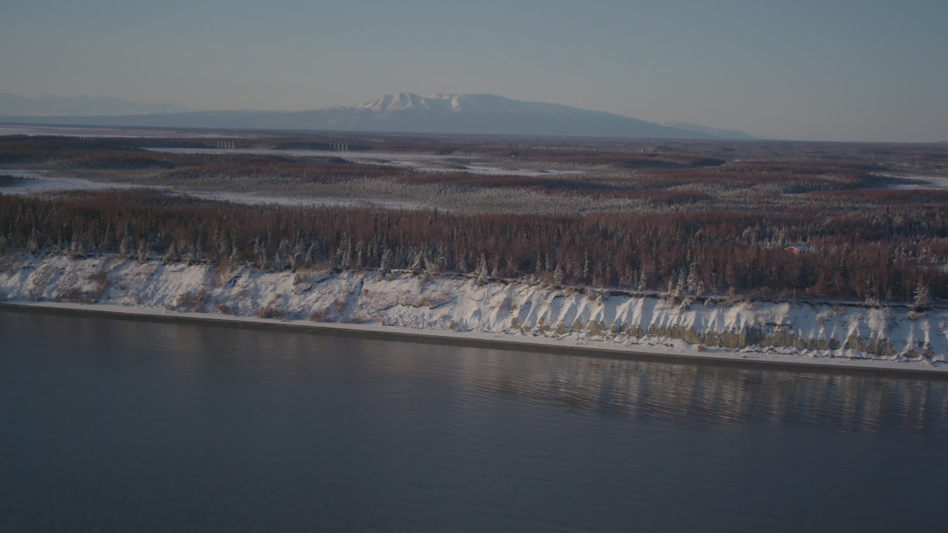 4K stock footage aerial video flying over snowy, wooded shore of Point