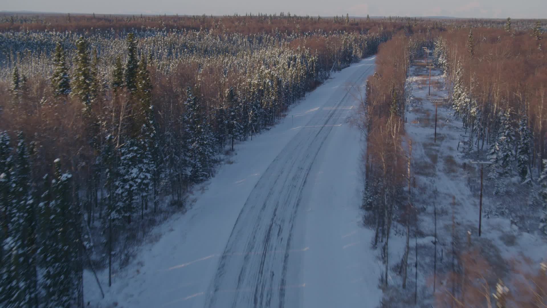 4K stock footage aerial video following a deserted rural snow covered