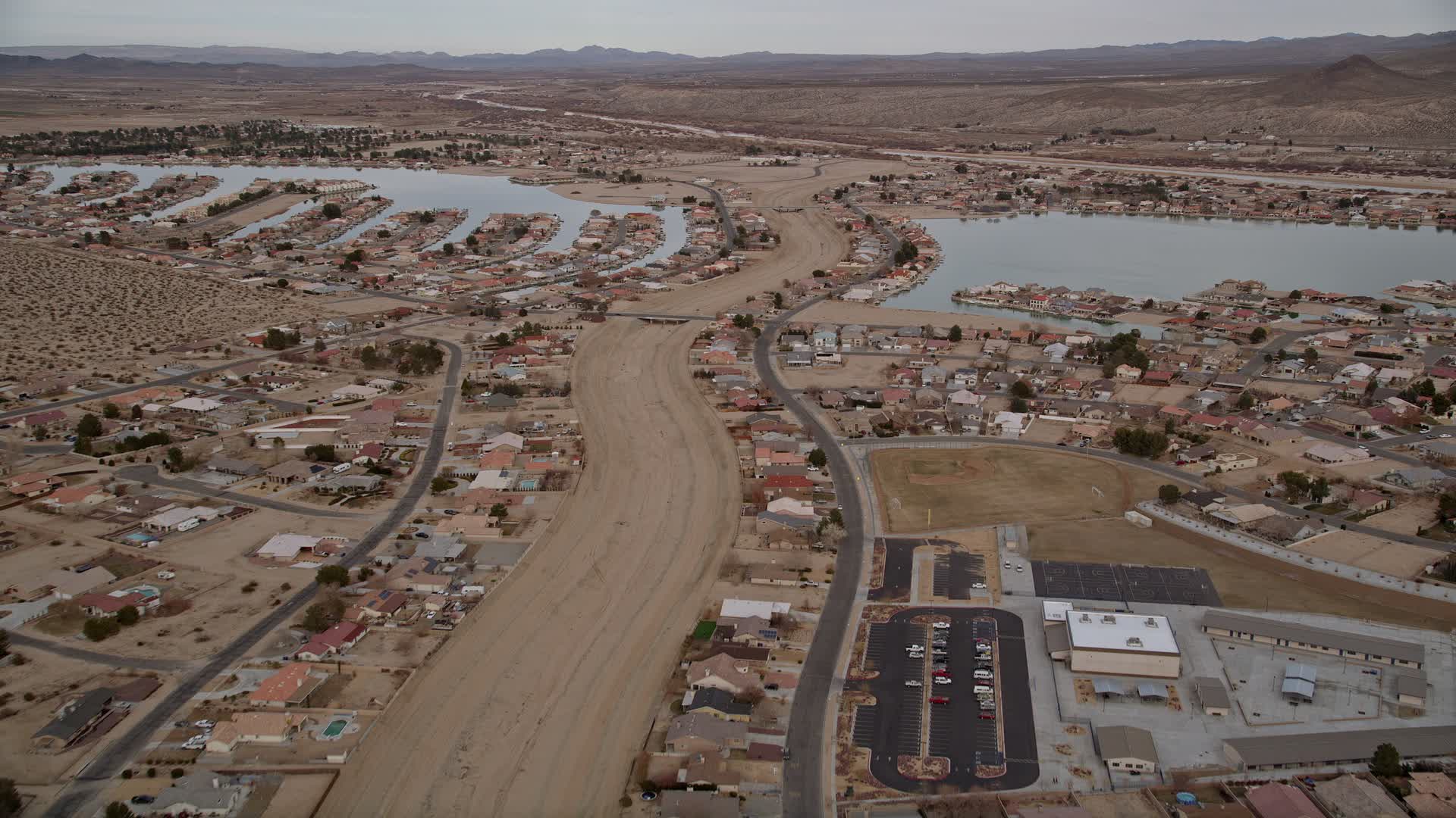 5K stock footage aerial video fly over small desert town with two lakes