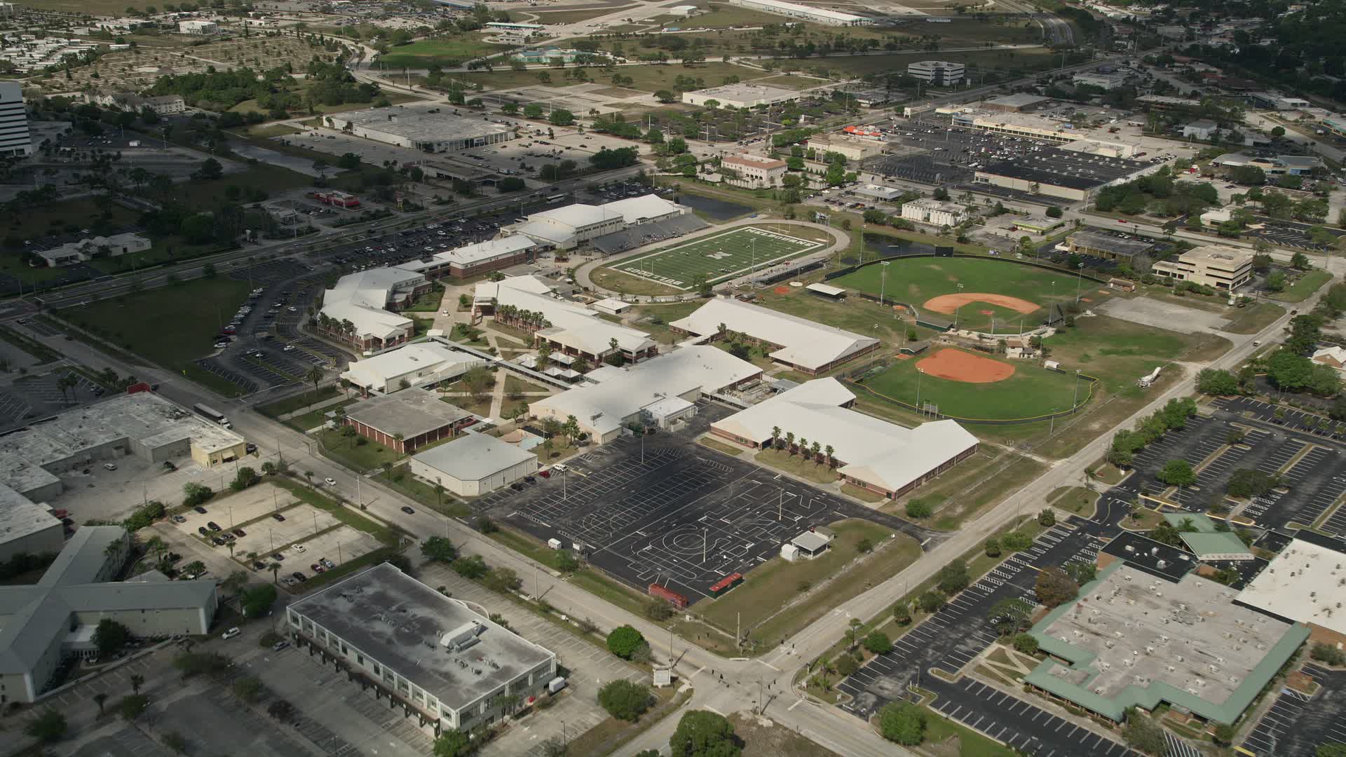 5K aerial stock footage video of approaching a high school and sports