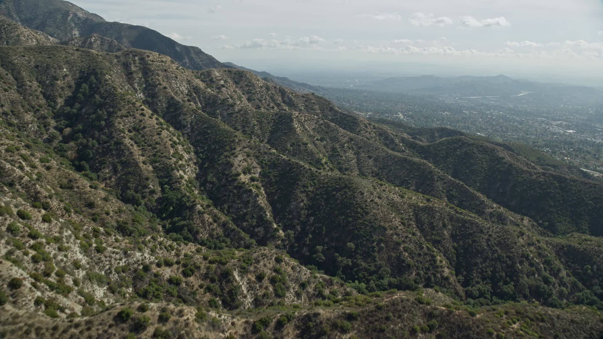 7.6K stock footage aerial video flying over green mountain ridges, La