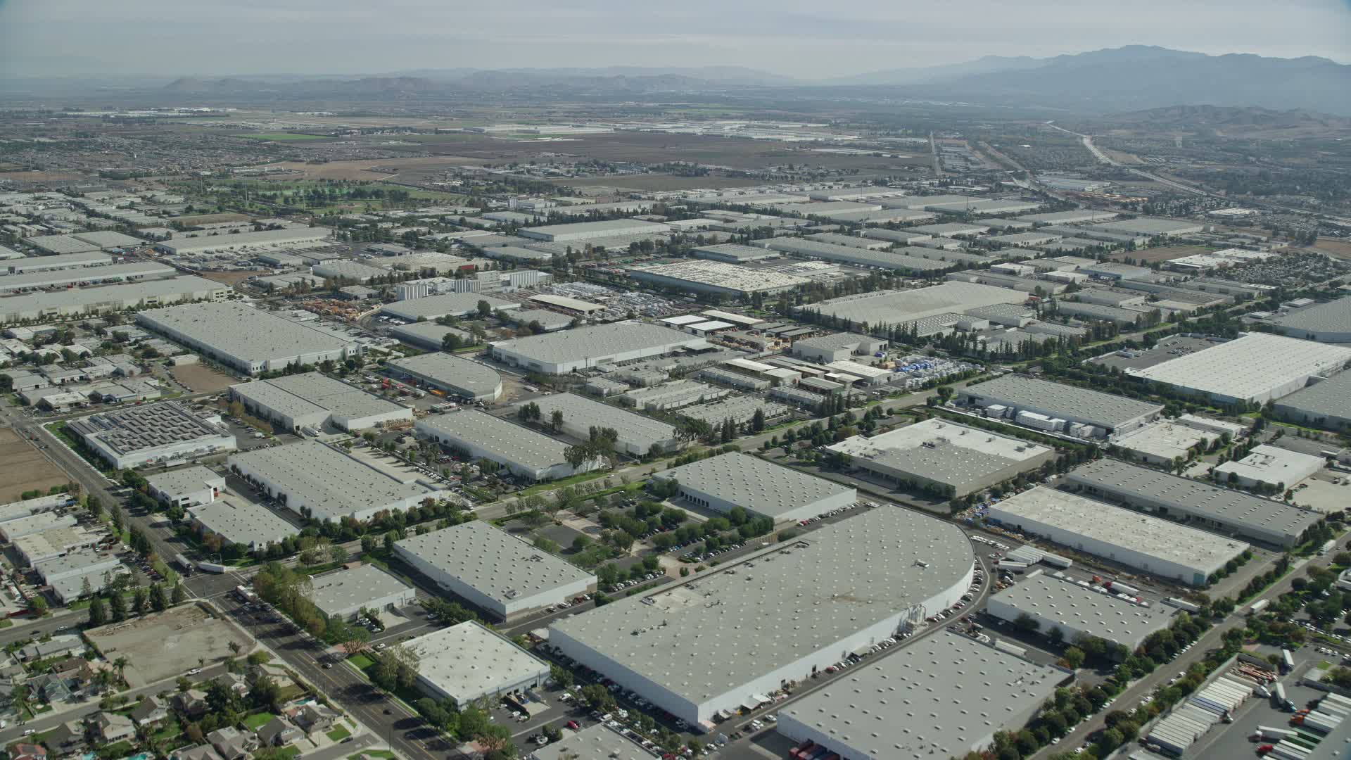 8K stock footage aerial video flying over numerous large warehouses in