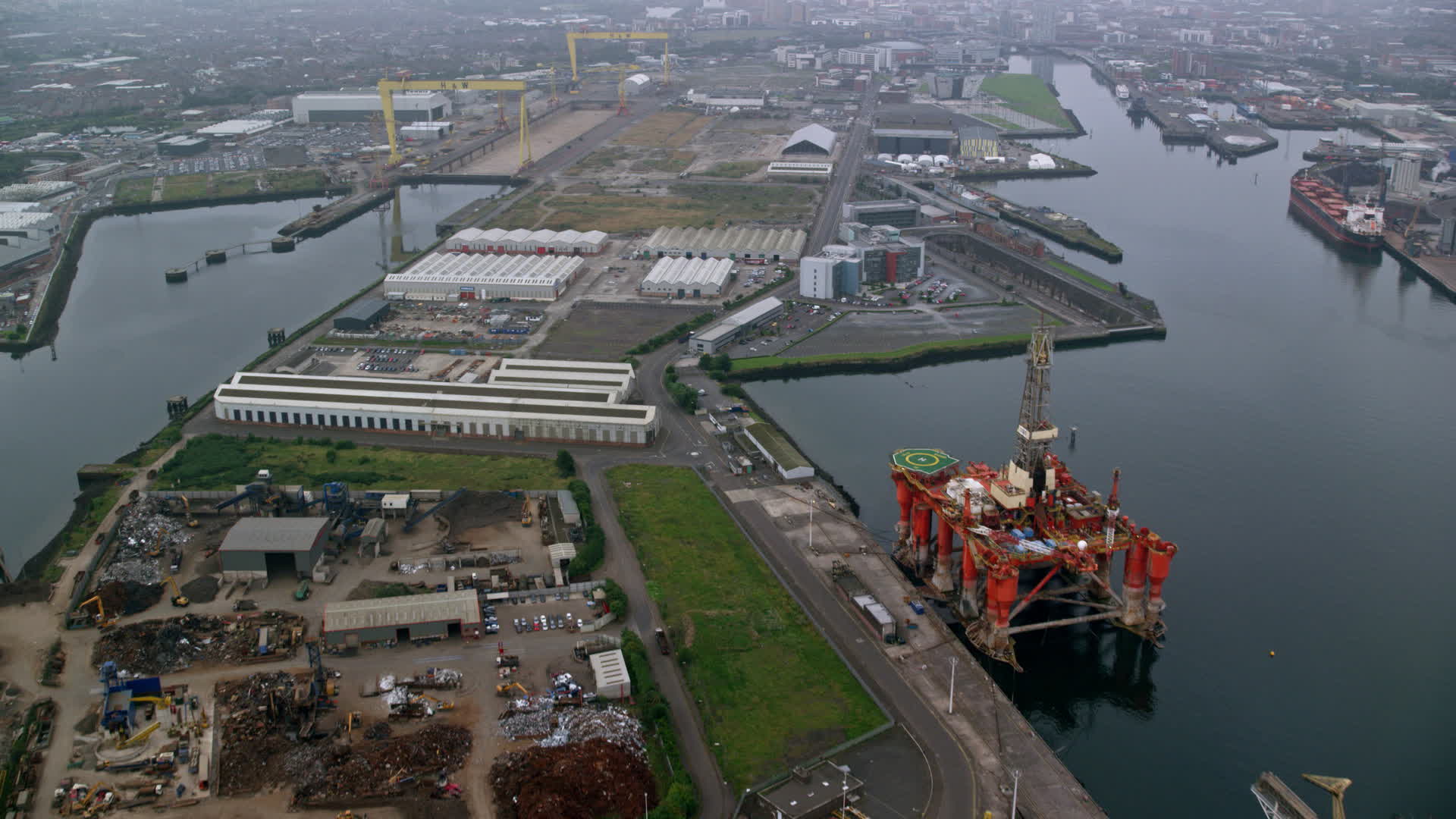 6K stock footage aerial video of flying over dock buildings at the Port of Belfast, Northern