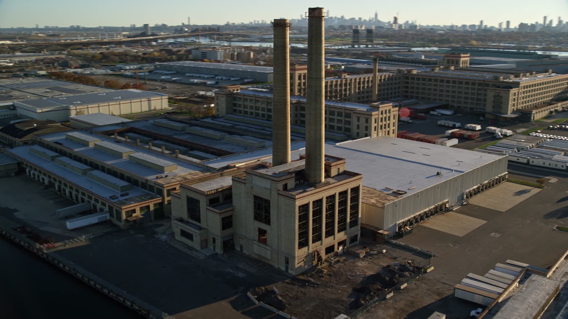 5.5K stock footage aerial video of orbiting a riverfront factory at