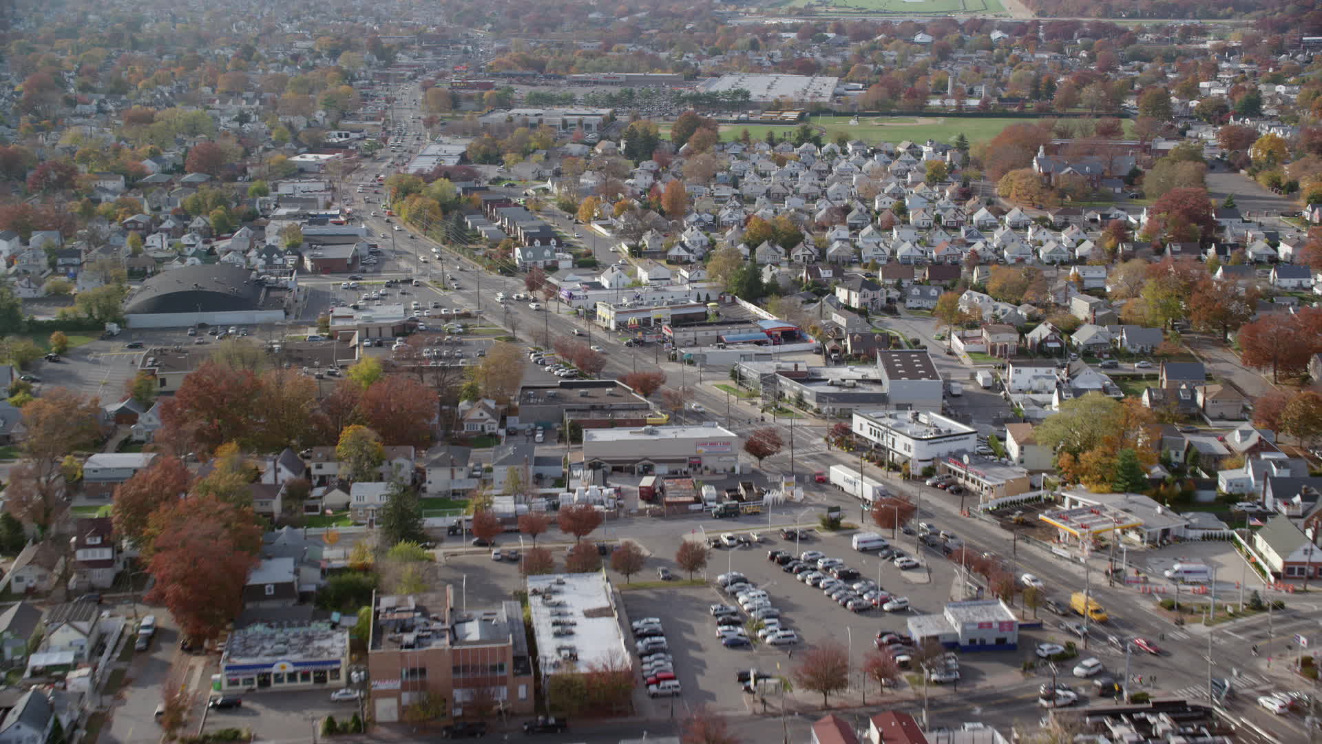 6K stock footage aerial video of suburbs and stores along a busy street