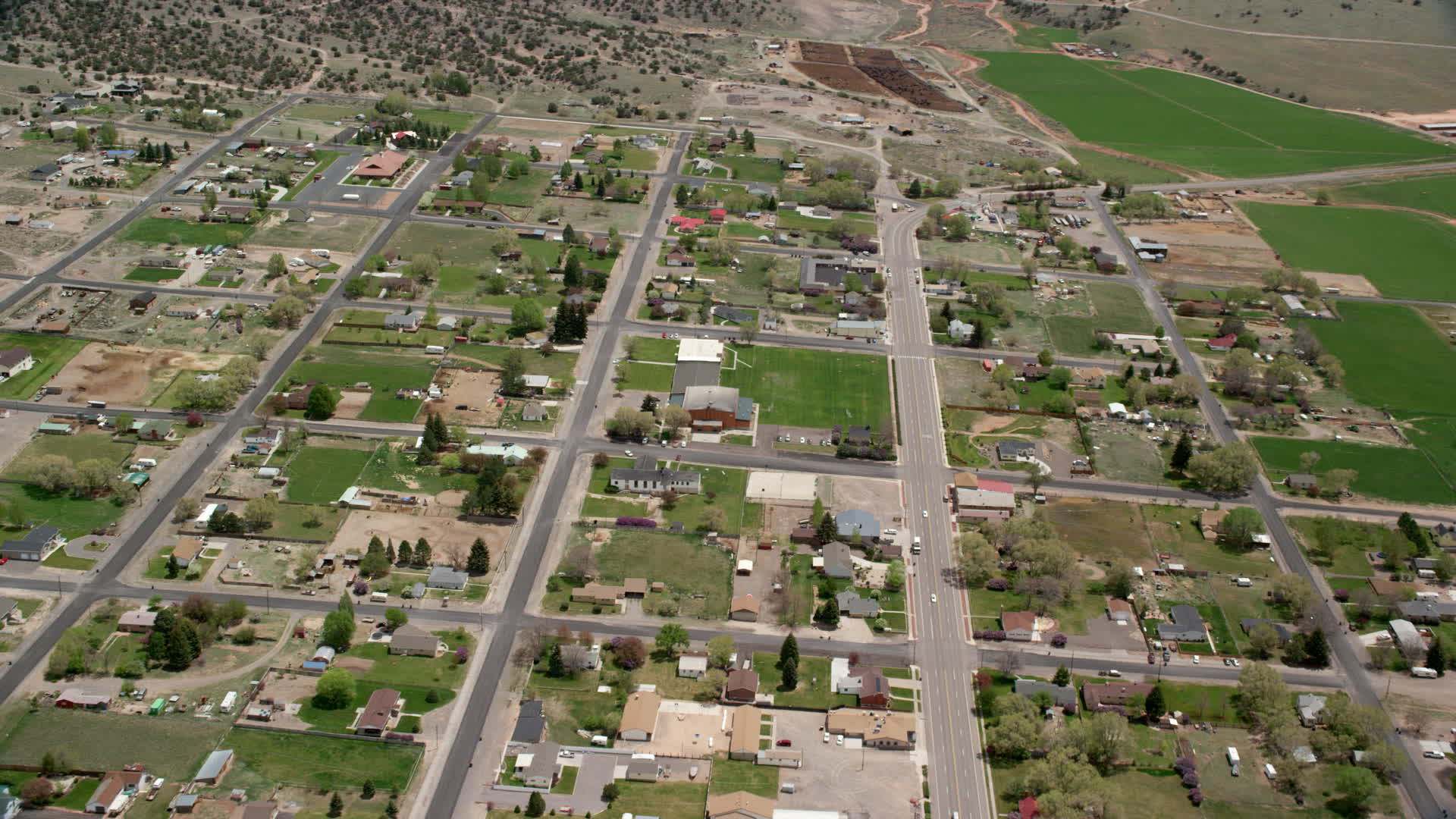 6K stock footage aerial video of flying by small rural town near hills