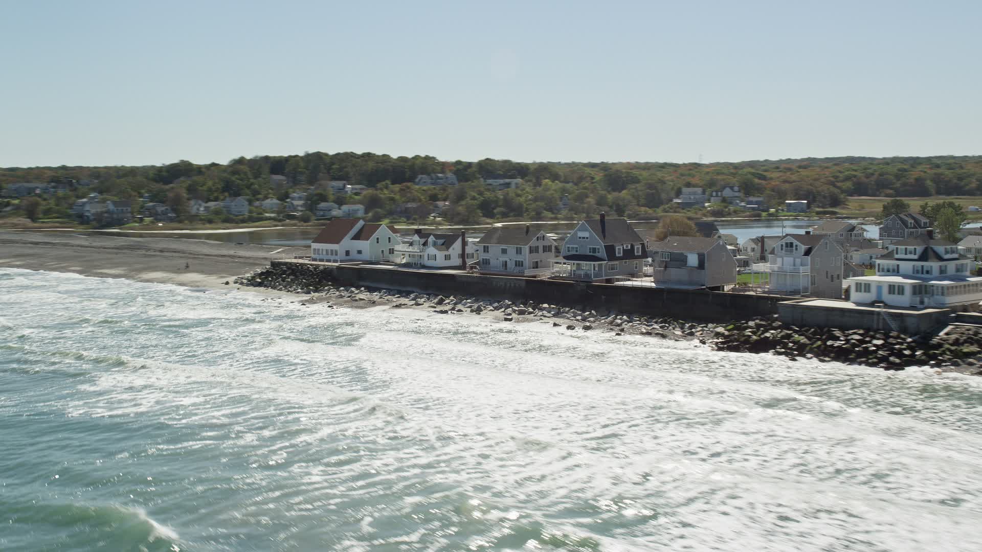 5.5K stock footage aerial video flying by oceanfront homes, pan right