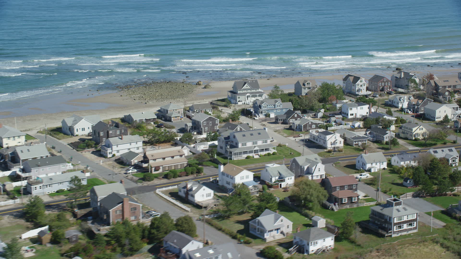 5.5K stock footage aerial video flying by oceanfront homes, waves