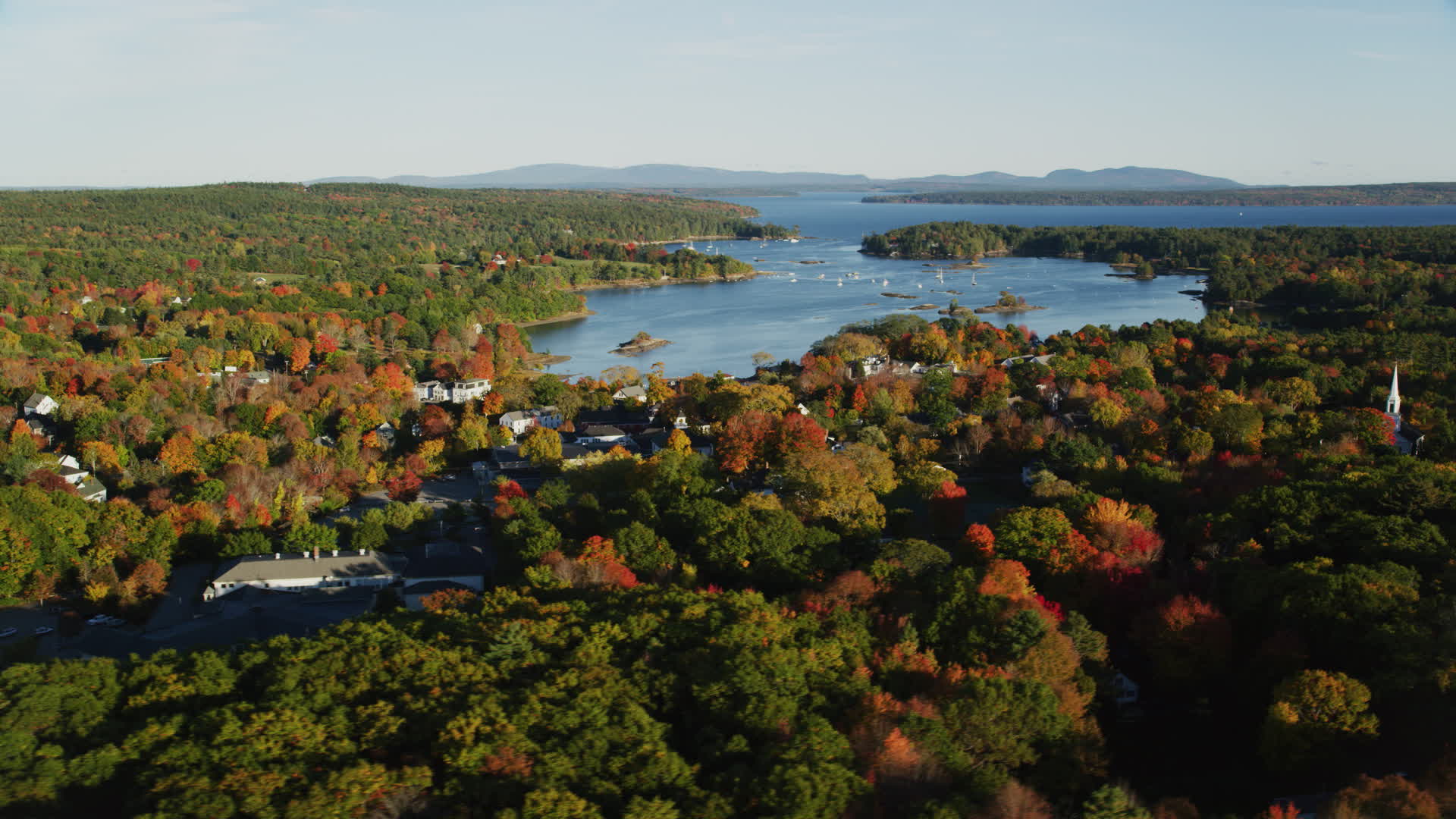 6K stock footage aerial video flying by coastal town and harbor among