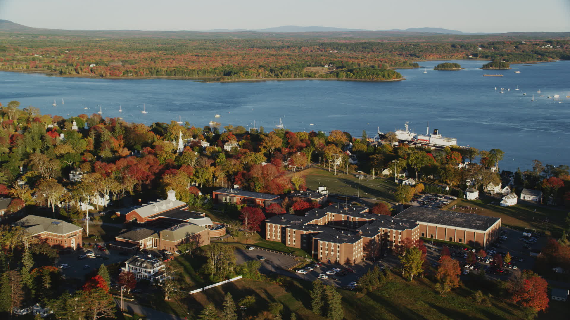 6K stock footage aerial video orbiting Maine Maritime Academy nestled among fall foliage, autumn