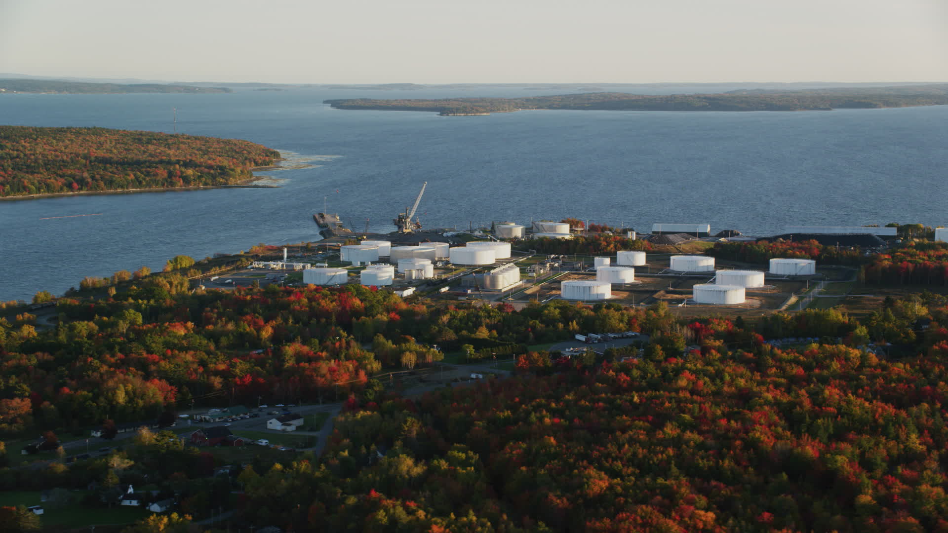 6K stock footage aerial video flying by oil refinery and gas company along the water, autumn