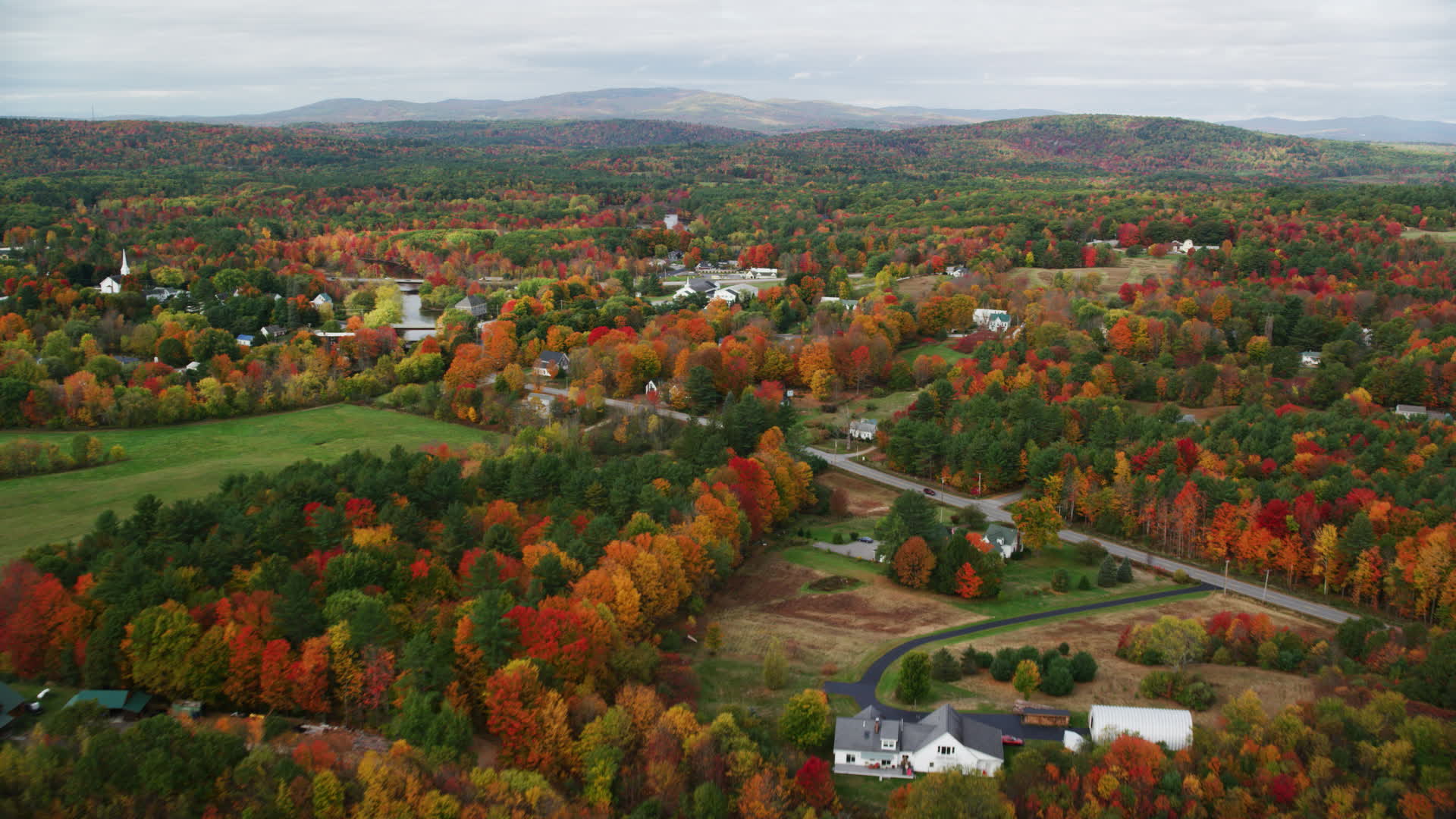 6K stock footage aerial video flying by a small rural town, colorful foliage in autumn, Turner