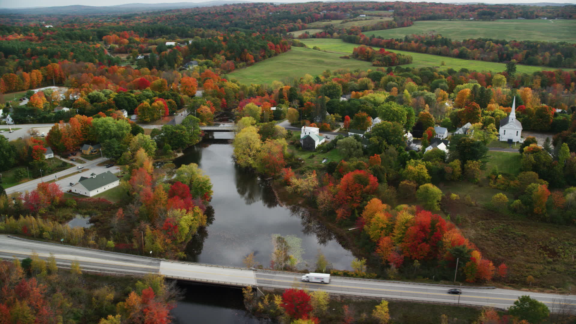 6K stock footage aerial video orbiting rural town, small bridges, Nezinscot River, autumn