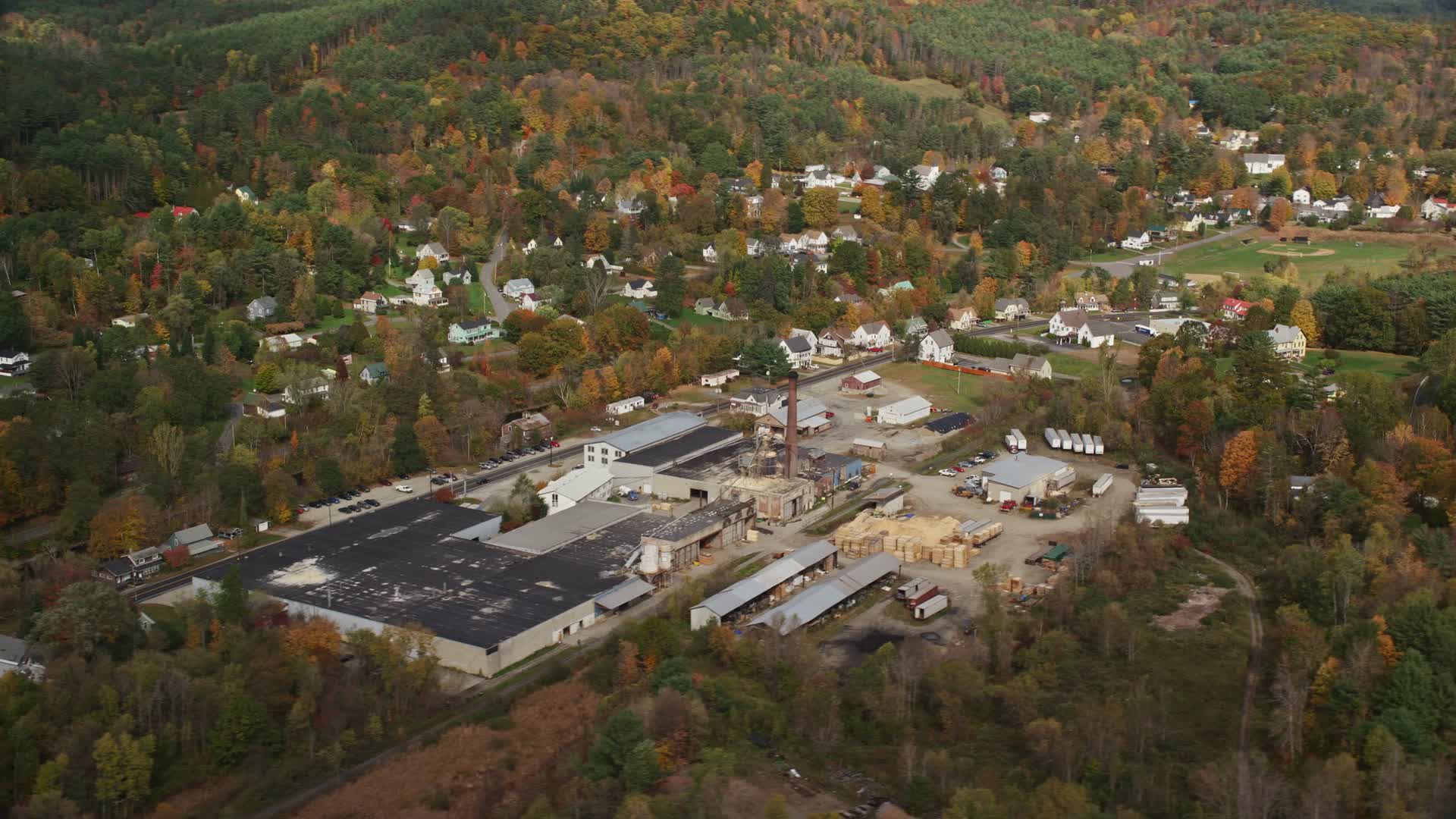 5.5K stock footage aerial video flying by a factory near river, small