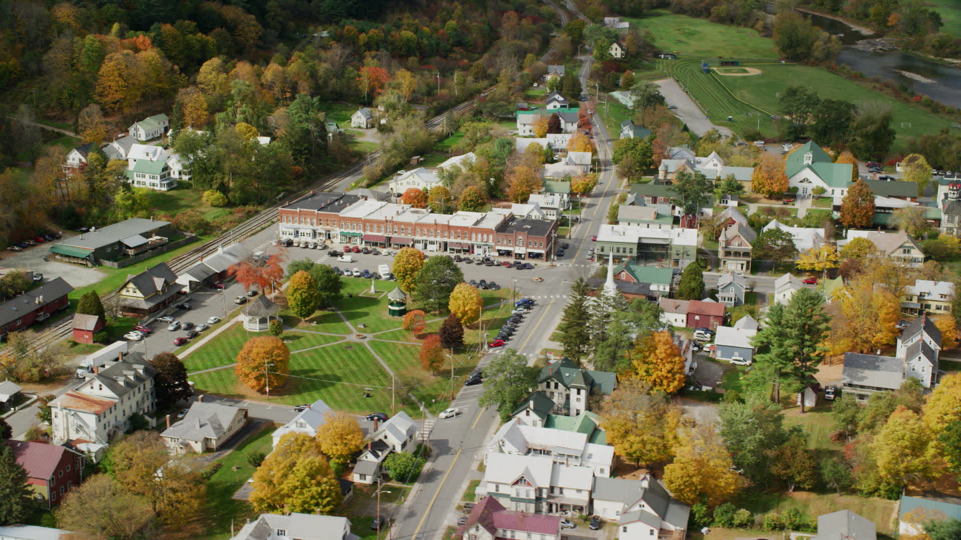 5.5K stock footage aerial video orbiting town square, row of shops