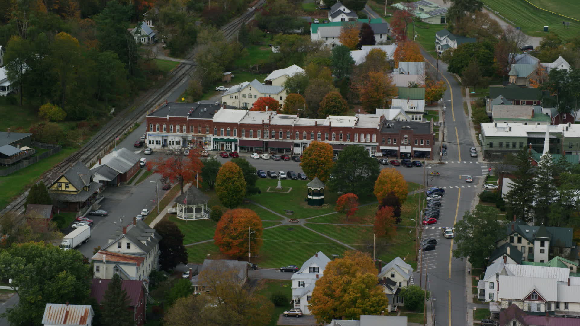 5.5K stock footage aerial video flying away from shops and town square in small rural town