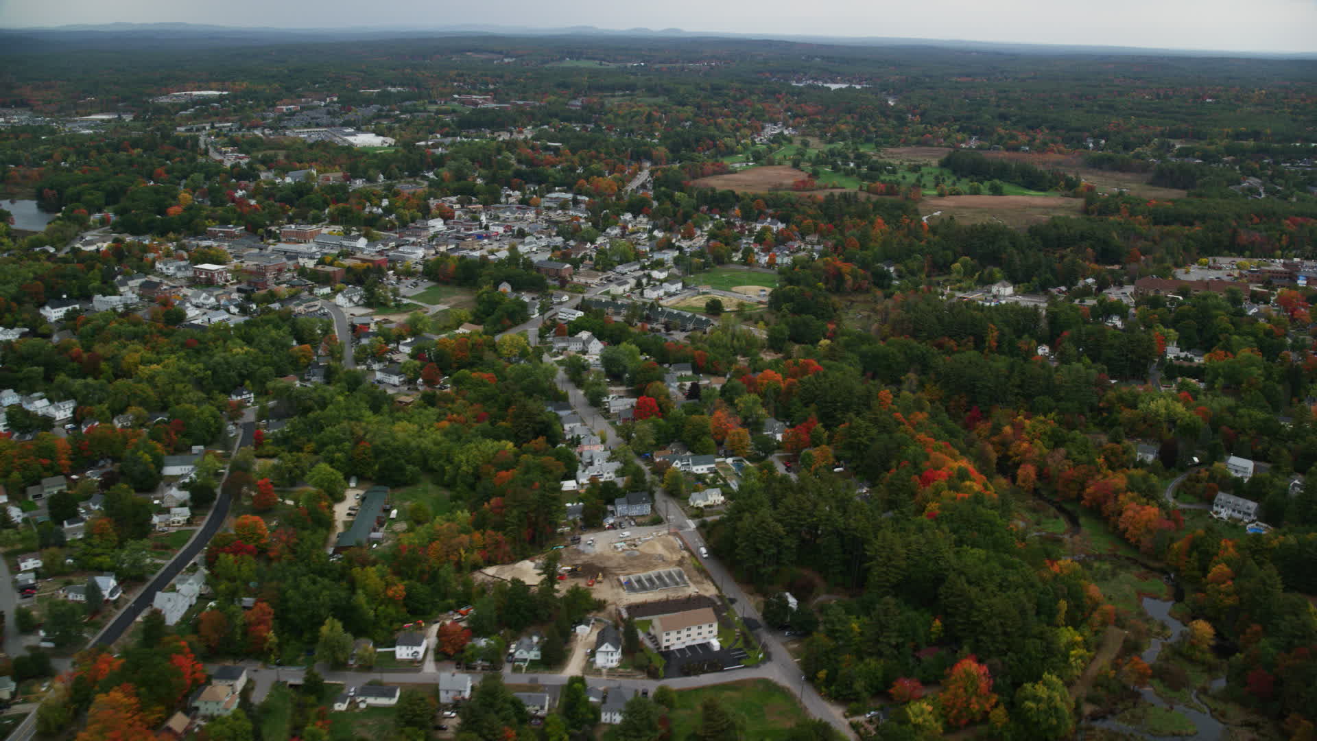 5.5K stock footage aerial video flying by homes, downtown area, colorful foliage in autumn