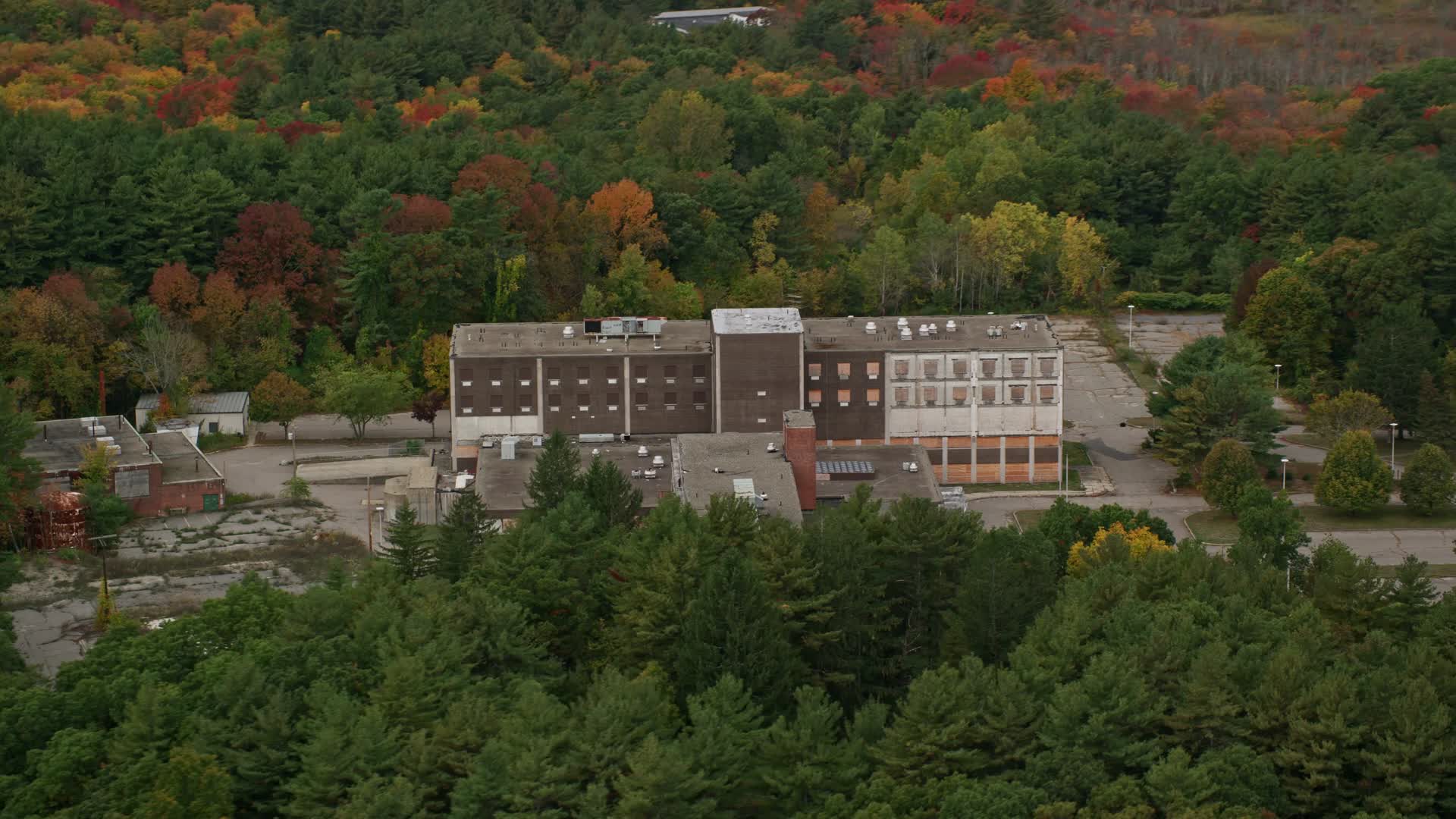 6K stock footage aerial video flying over fall foliage toward abandoned