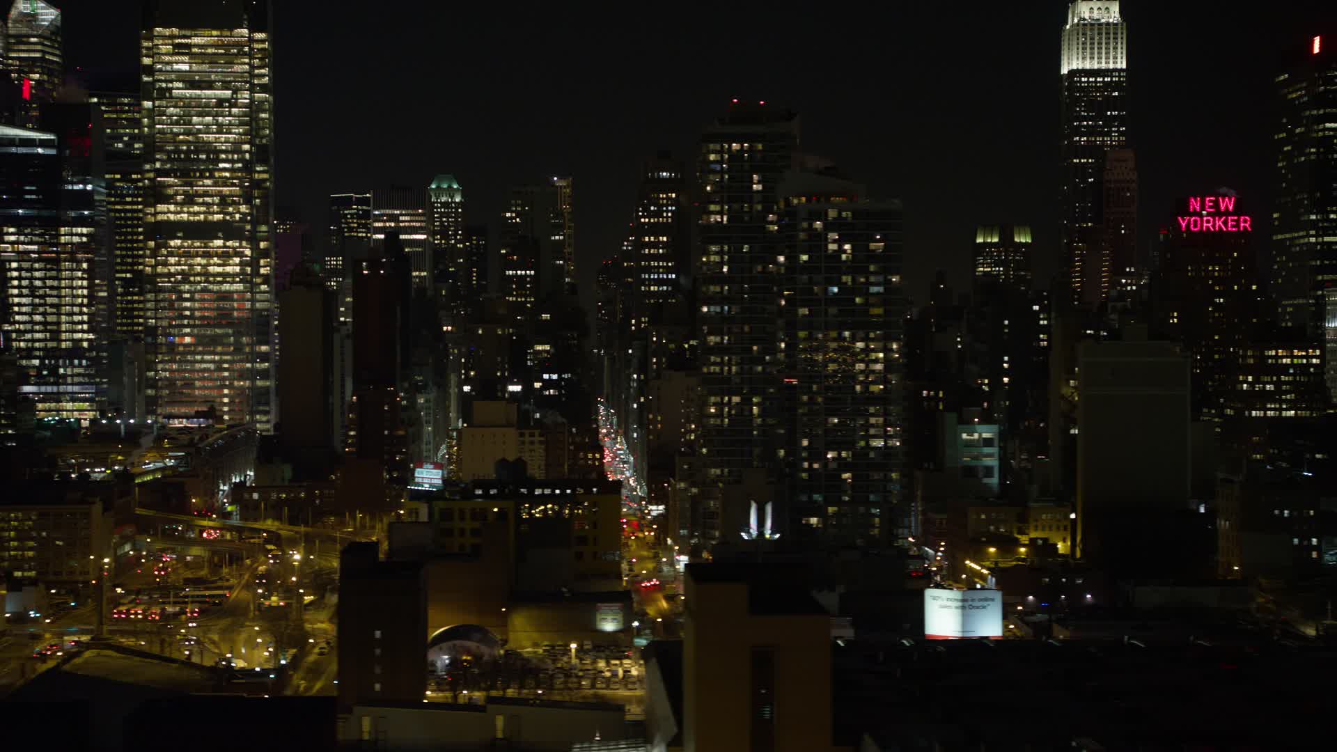 4K stock video aerial view of passing Hell's Kitchen area of Midtown Manhattan at night, New