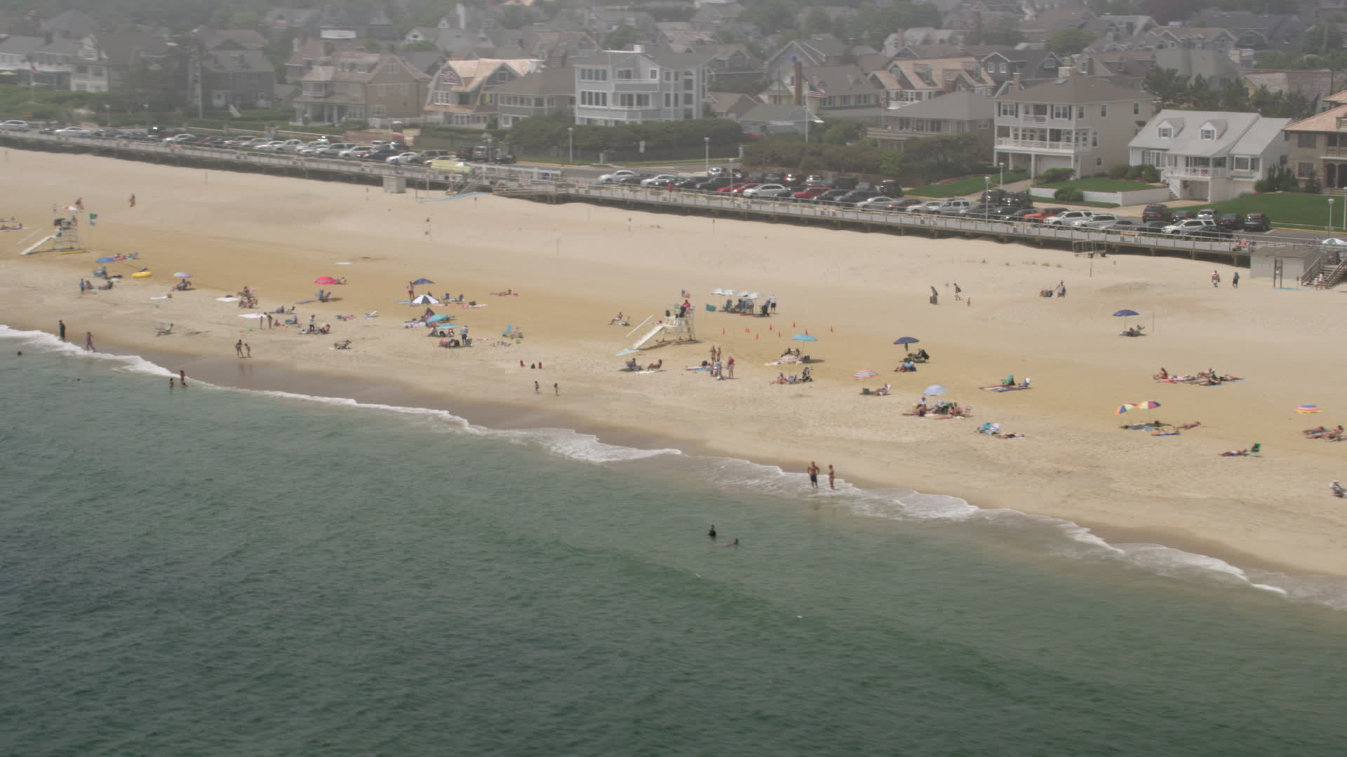 5K stock footage aerial video of sunbathers and lifeguard on the beach