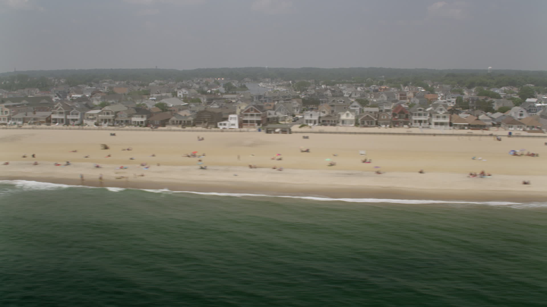 5K stock footage aerial video of sunbathers and beachfront homes in