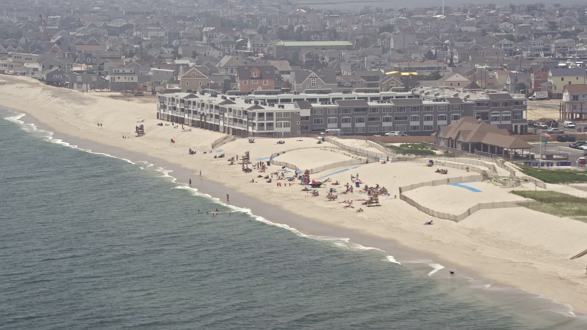 5K stock footage aerial video of sunbathers at a beach, Mantoloking