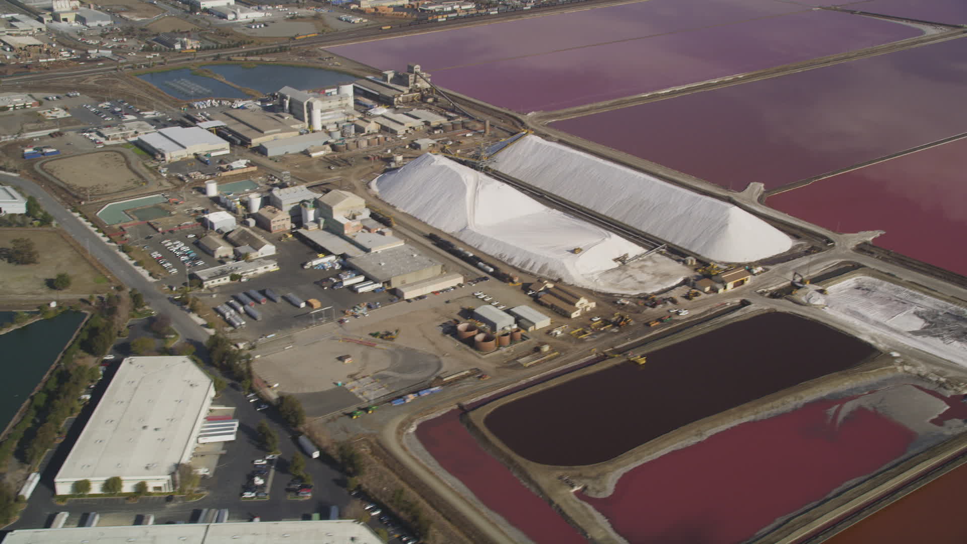 5K stock footage aerial video of flying by Morton Salt Plant and salt