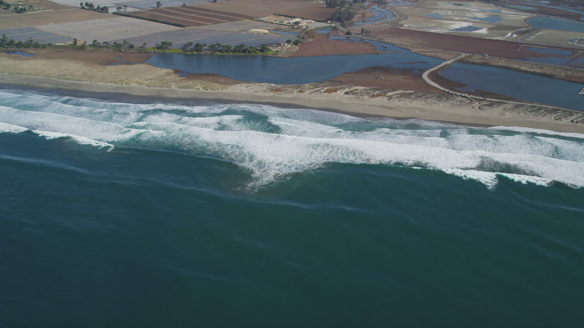 5K stock footage aerial video of flying by waves rolling toward a beach