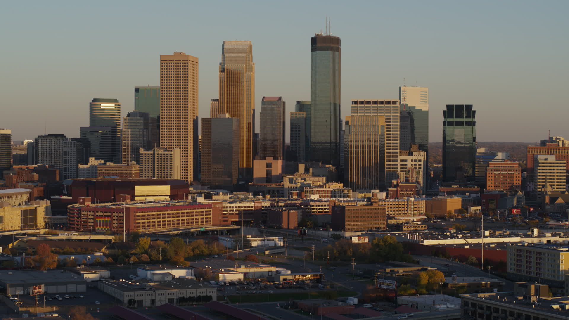 5.7K stock footage aerial video of slowly flying by the city's downtown skyline at sunset in