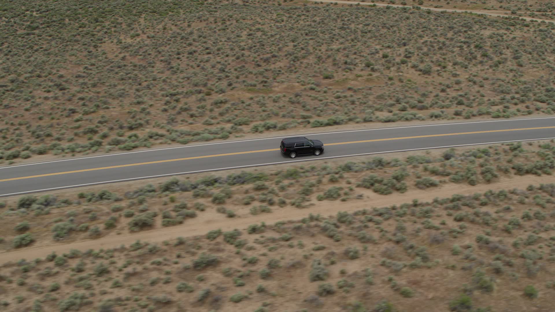 5.7K stock footage aerial video track a black SUV as it drives on a