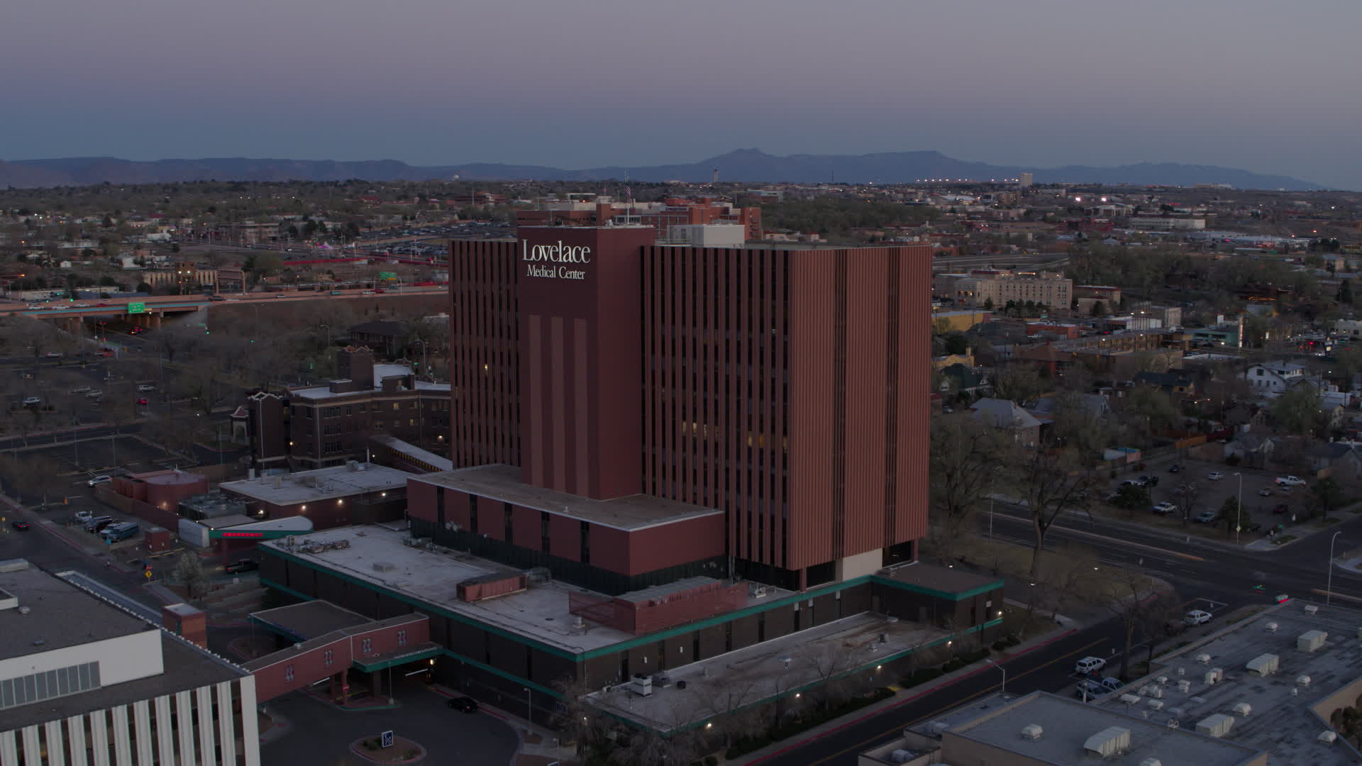 5.7K stock footage aerial video of a reverse view of a hospital at sunset in Albuquerque, New
