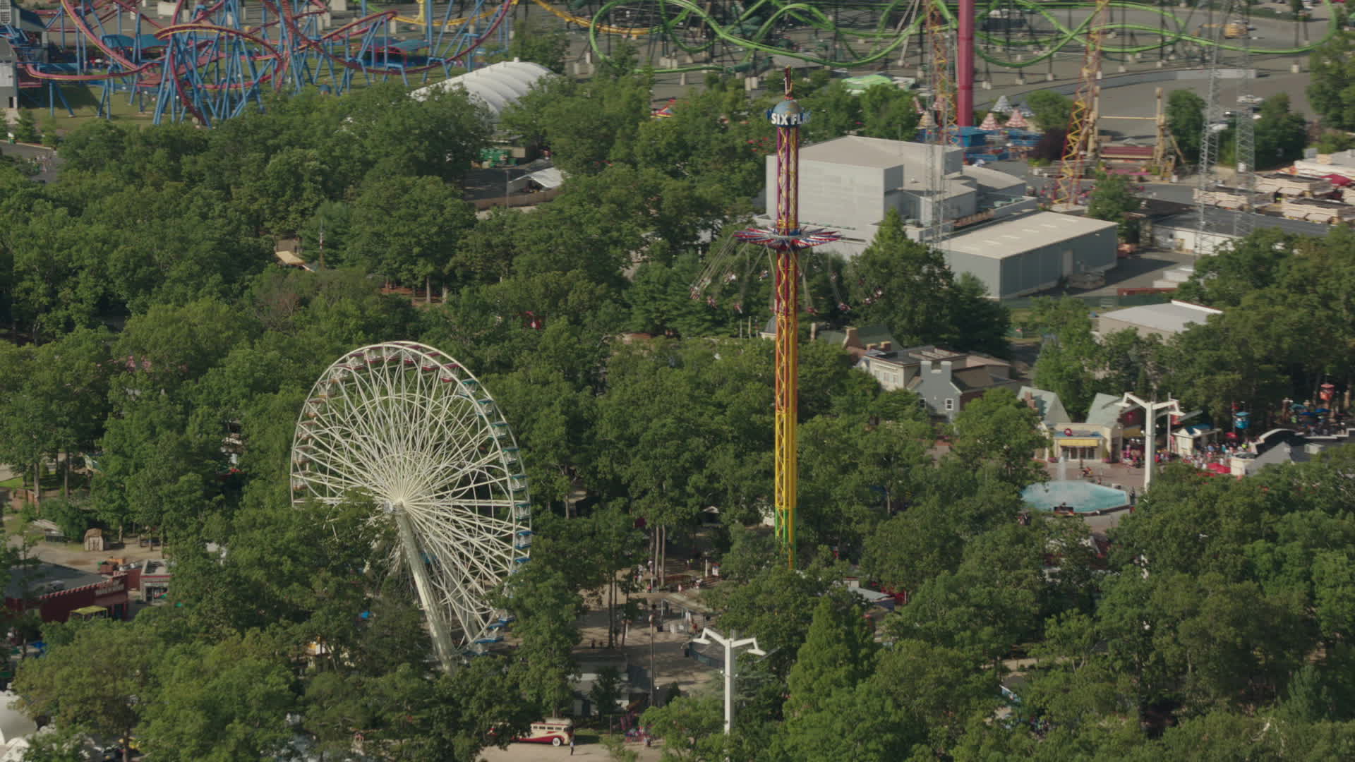 HD stock footage aerial video of a Ferris wheel and rides at Six Flags