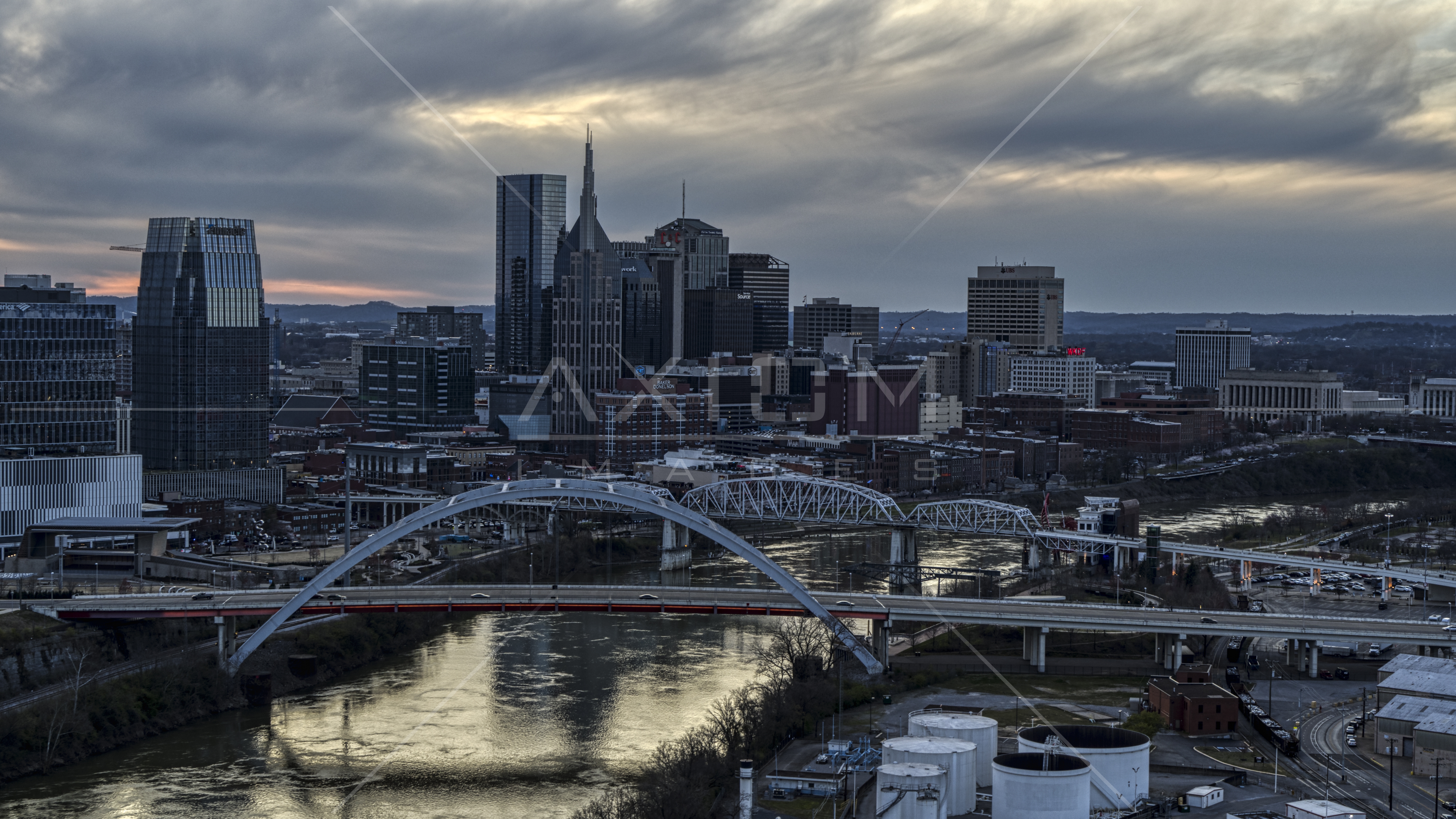 The riverfront skyline, two bridges, and the Cumberland River at sunset
