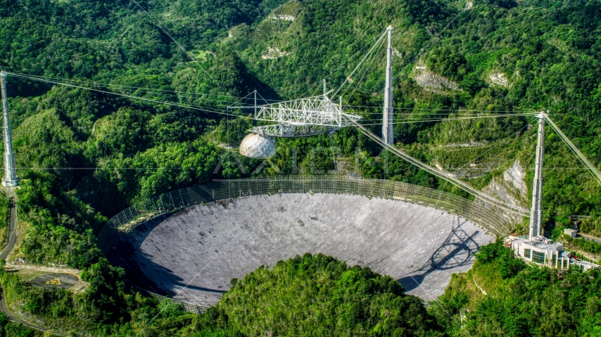 Arecibo Observatory nestled in the lush green forest, Puerto Rico Aerial Stock Photo AX101_092.0000000F | Axiom Images