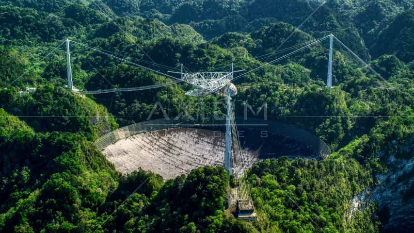 A view of the Arecibo Observatory surrounded by trees, Puerto Rico Aerial Stock Photo AX101_097.0000000F | Axiom Images