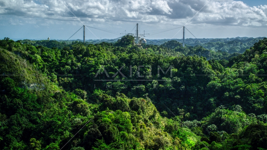 Arecibo Observatory seen from lush green mountains, Puerto Rico Aerial Stock Photo AX101_108.0000184F | Axiom Images