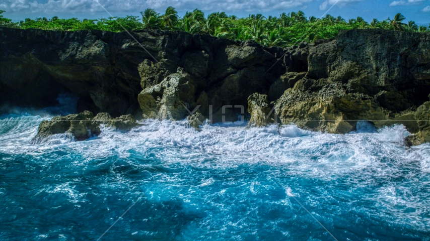 Coastal rock formations and caves, and crashing ocean waves in Arecibo, Puerto Rico Aerial Stock Photo AX101_163.0000000F | Axiom Images