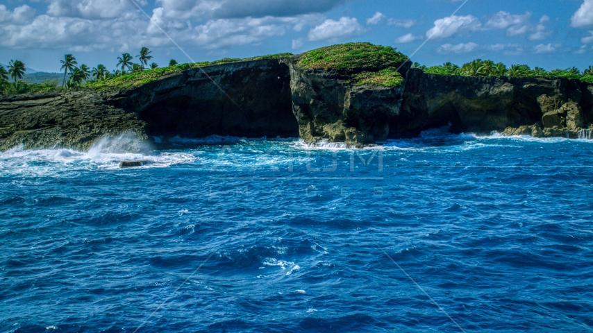 Rock formations on the rugged island coast and crystal blue water, Arecibo, Puerto Rico Aerial Stock Photo AX101_165.0000040F | Axiom Images