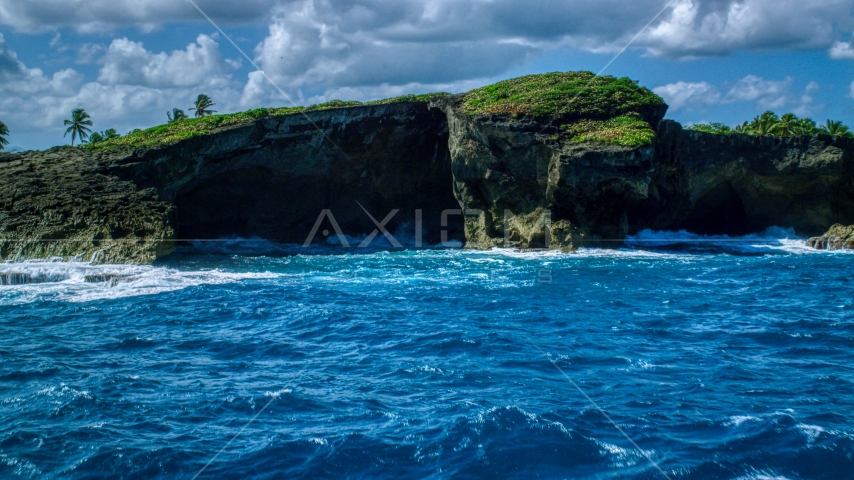 Rock formations on the rugged coast with crystal blue water, Arecibo, Puerto Rico Aerial Stock Photo AX101_165.0000153F | Axiom Images
