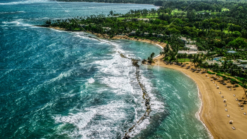 Waves hitting the breakwater by a Caribbean beach resort in Dorado, Puerto Rico Aerial Stock Photo AX101_214.0000000F | Axiom Images
